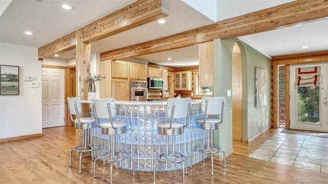 dining area with light wood-type flooring, beam ceiling, recessed lighting, crown molding, and baseboards