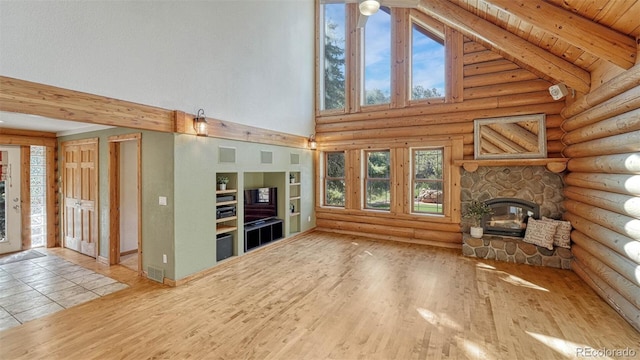 unfurnished living room featuring beamed ceiling, visible vents, high vaulted ceiling, wood finished floors, and a stone fireplace