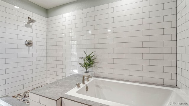 bathroom featuring a garden tub and a tile shower