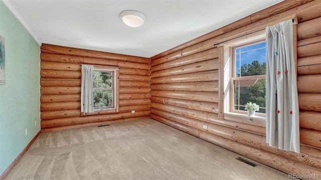 spare room with visible vents, log walls, baseboards, and carpet floors