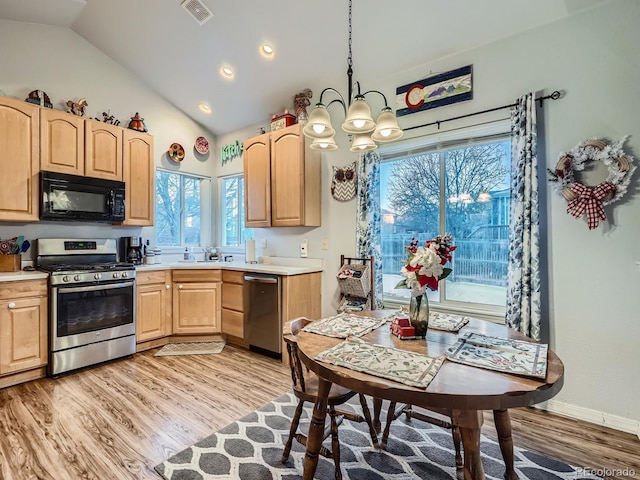 kitchen with appliances with stainless steel finishes, vaulted ceiling, light wood-type flooring, pendant lighting, and light brown cabinets