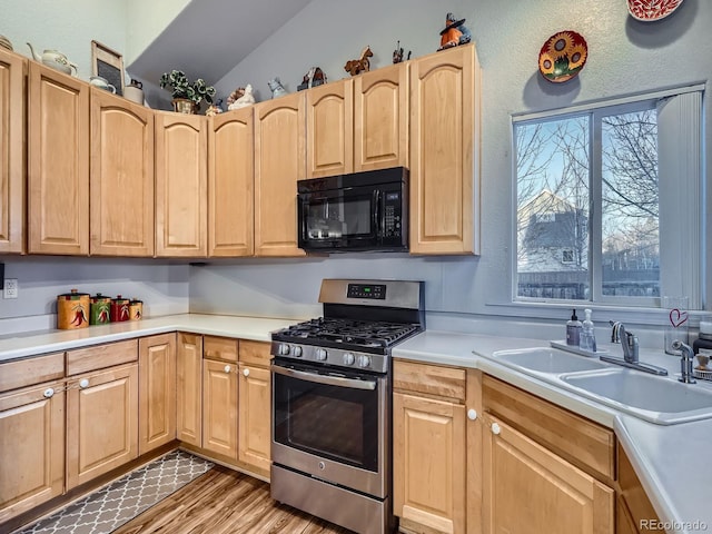 kitchen featuring hardwood / wood-style flooring, sink, light brown cabinetry, and gas range