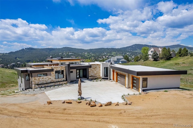 545 Strada Rossa Rd, Golden, CO 80401 - modern home with a mountain view, concrete driveway, an attached garage, and stone siding