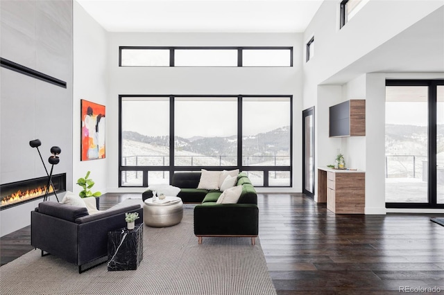 545 Strada Rossa Rd, Golden, CO 80401 - living area with a mountain view, a tiled fireplace, a high ceiling, dark wood-type flooring, and plenty of natural light