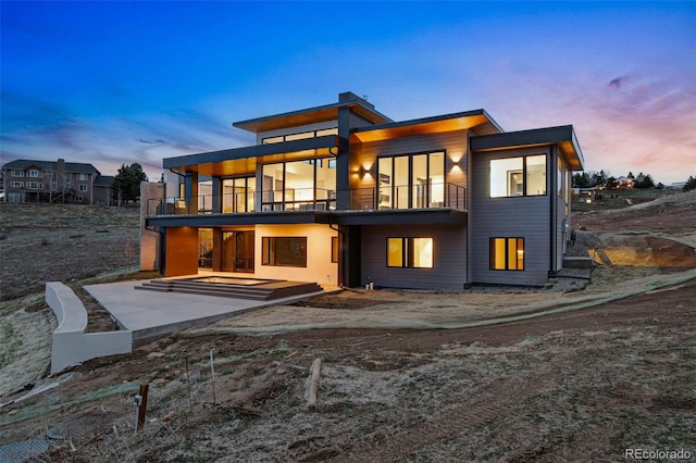 545 Strada Rossa Rd, Golden, CO 80401 - back of property at dusk with a balcony and a patio