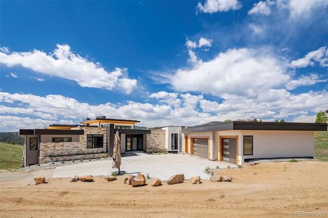 545 Strada Rossa Rd, Golden, CO 80401 - modern home featuring a garage, stone siding, and driveway