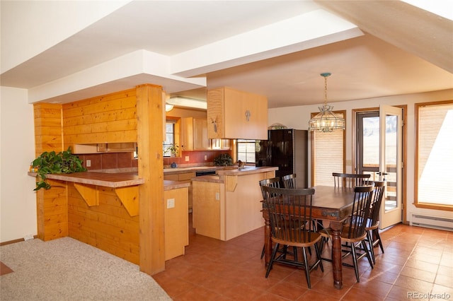 kitchen with tasteful backsplash, light brown cabinetry, a breakfast bar, kitchen peninsula, and light tile patterned floors