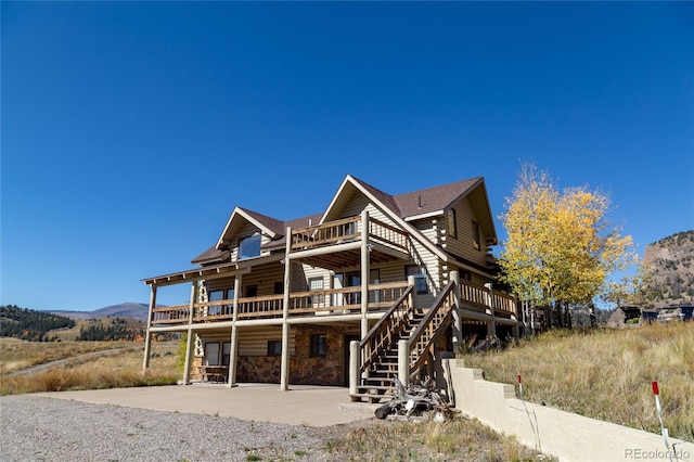 back of property featuring a deck with mountain view