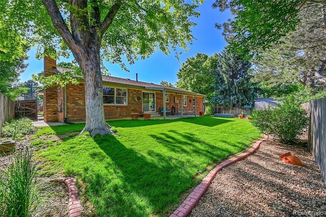 12348 Elizabeth Ct, Thornton, CO 80241 - rear view of house featuring a chimney, brick siding, and a patio