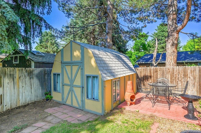 12348 Elizabeth Ct, Thornton, CO 80241 - view of shed featuring a fenced backyard and outdoor dining space