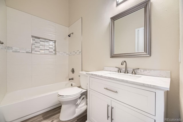 full bathroom featuring vanity, wood-type flooring, tiled shower / bath combo, and toilet