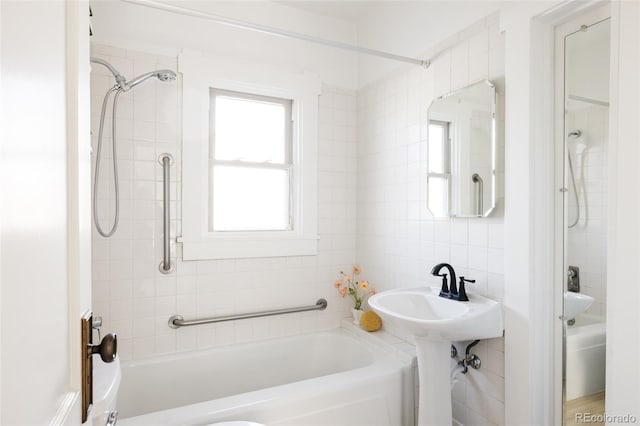 bathroom with tiled shower / bath, decorative backsplash, and tile walls