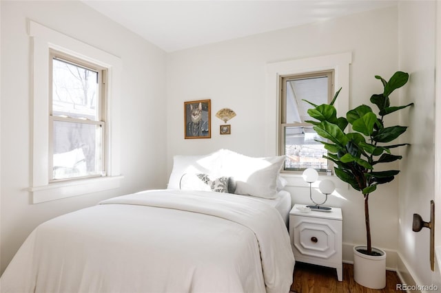 bedroom with dark wood-type flooring and multiple windows