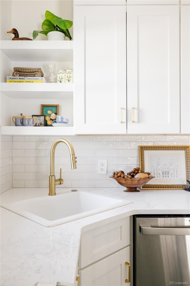 interior space with light stone countertops, white cabinets, and stainless steel dishwasher