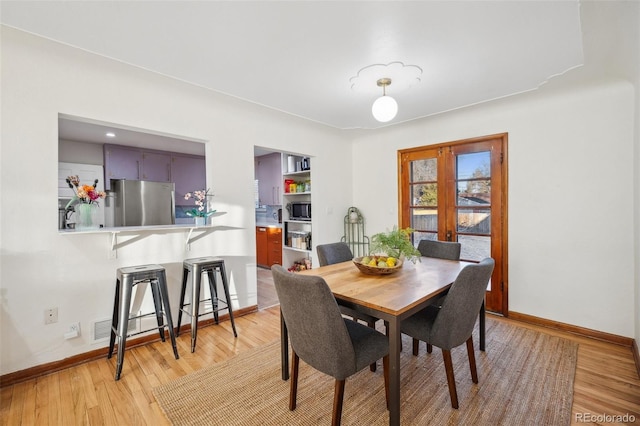 dining room with hardwood / wood-style floors and french doors