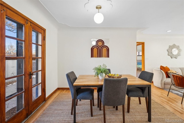 dining area featuring light wood-type flooring and french doors