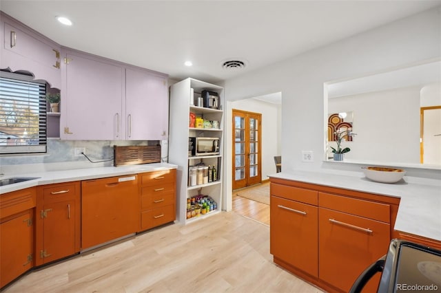 kitchen with french doors, range, light hardwood / wood-style flooring, dishwashing machine, and backsplash