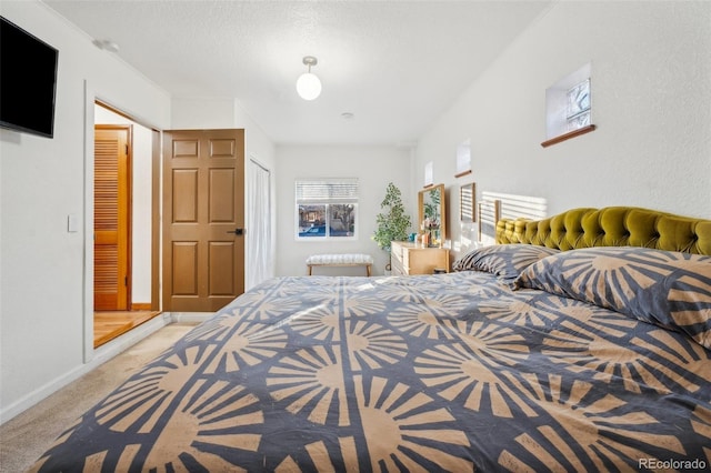 bedroom featuring light carpet and a textured ceiling