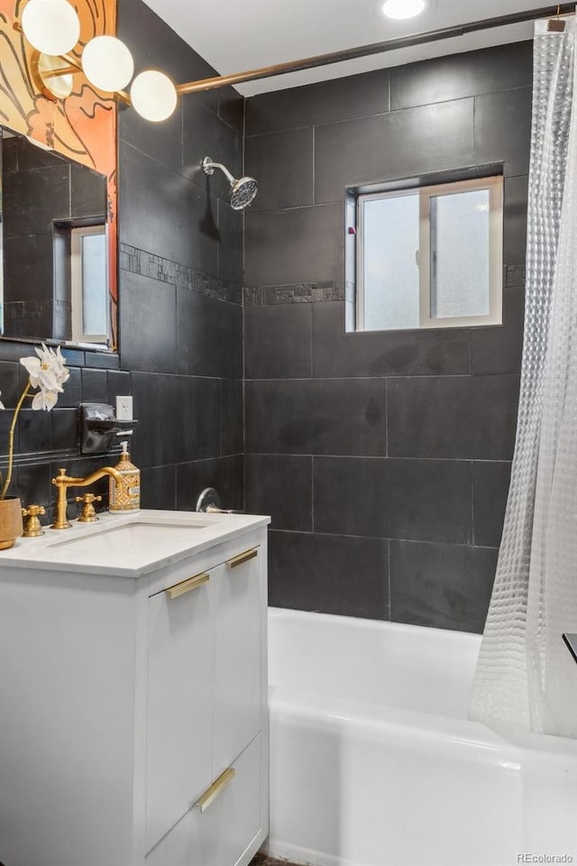 bathroom with vanity, shower / bath combo with shower curtain, and tile walls