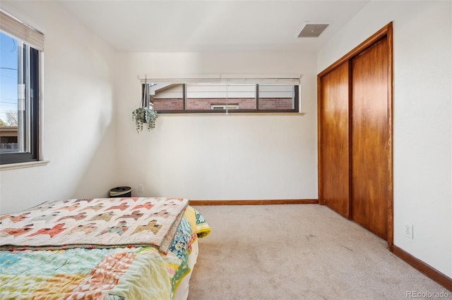 bedroom featuring a closet and light carpet