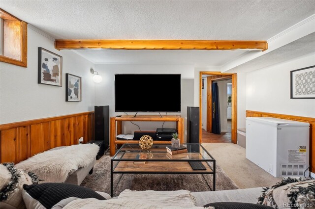 carpeted living room with crown molding, beamed ceiling, wooden walls, and a textured ceiling