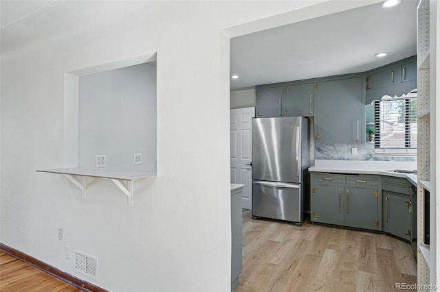2042 Jamaica St, Aurora, CO 80010 - kitchen with freestanding refrigerator, light wood-style floors, light countertops, recessed lighting, and tasteful backsplash