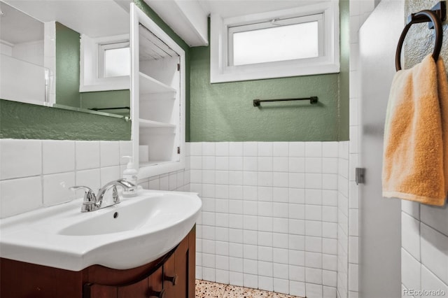 2042 Jamaica St, Aurora, CO 80010 - bathroom featuring tile walls, speckled floor, vanity, and wainscoting