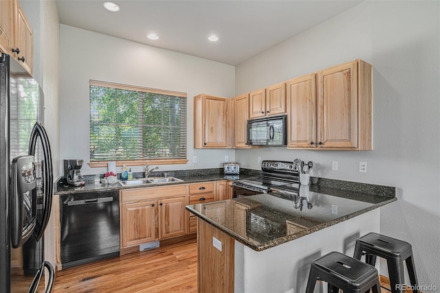 109 Peak Vw, Granby, CO 80446 - kitchen with black appliances, a sink, a peninsula, light brown cabinetry, and dark stone countertops