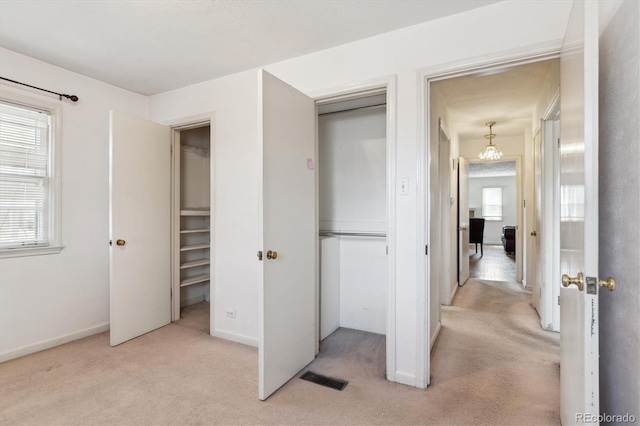 3201 S Albion St, Denver, CO 80222 - unfurnished bedroom with light carpet, a closet, baseboards, and a chandelier