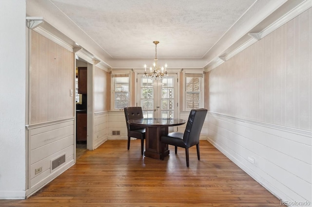 3201 S Albion St, Denver, CO 80222 - dining room featuring a chandelier, hardwood / wood-style flooring, a textured ceiling, and wainscoting