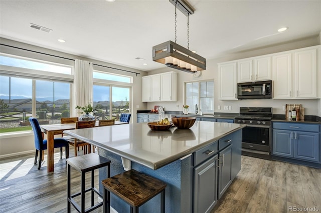 6880 Backcountry Loop, Colorado Springs, CO 80927 - kitchen with stainless steel gas range oven, black microwave, plenty of natural light, white cabinetry, and recessed lighting