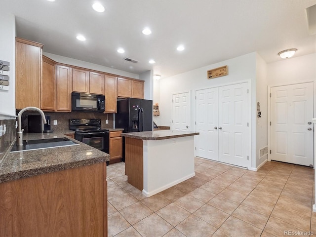 3662 S Perth Cir Unit 104, Aurora, CO 80013 - kitchen featuring black appliances, a kitchen island, dark countertops, tasteful backsplash, and light tile patterned flooring