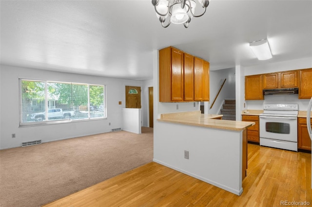 6953 Ingalls St, Arvada, CO 80003 - kitchen featuring white electric range oven, exhaust hood, light countertops, and light wood-type flooring