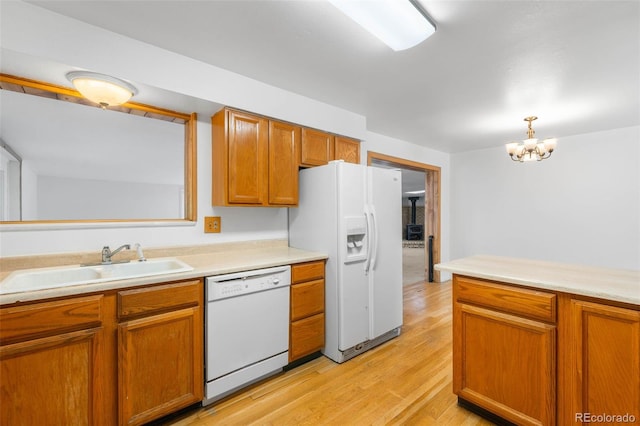 6953 Ingalls St, Arvada, CO 80003 - kitchen featuring white appliances, a sink, a chandelier, and light countertops
