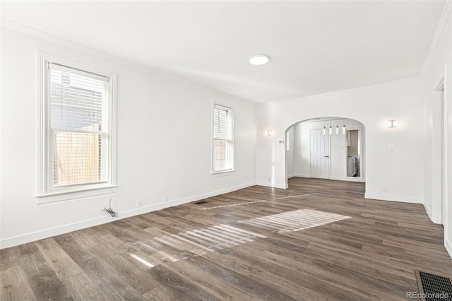 spare room featuring dark hardwood / wood-style flooring and crown molding