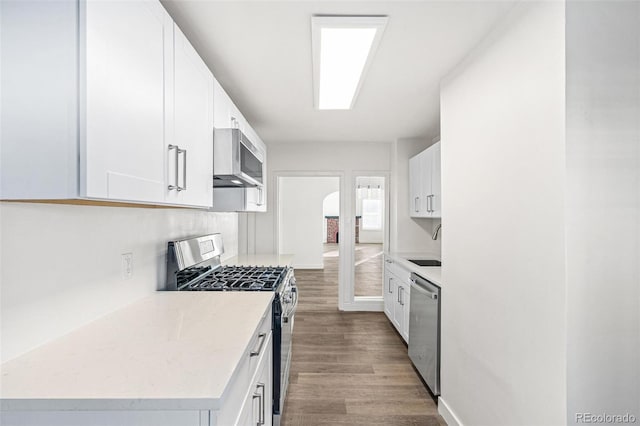 kitchen featuring white cabinets, sink, light wood-type flooring, and stainless steel appliances