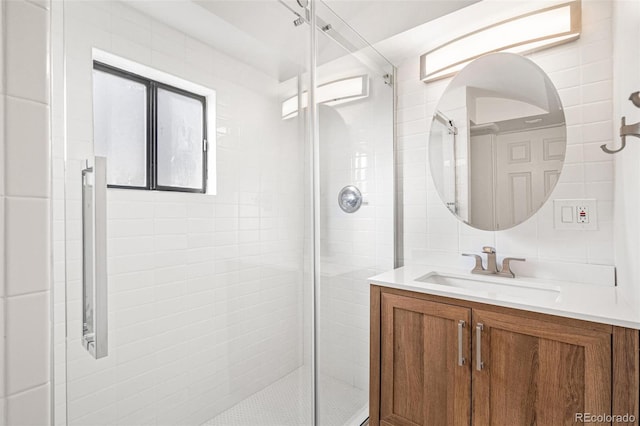 bathroom featuring decorative backsplash, vanity, and a shower with shower door