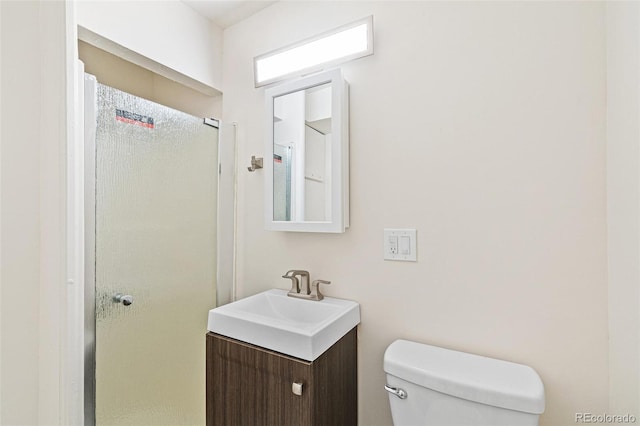 bathroom featuring walk in shower, vanity, and toilet