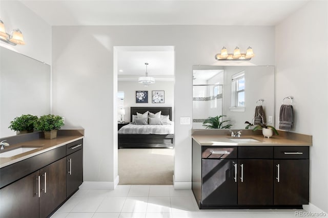 ensuite bathroom featuring tile patterned flooring, two vanities, a sink, and ensuite bath