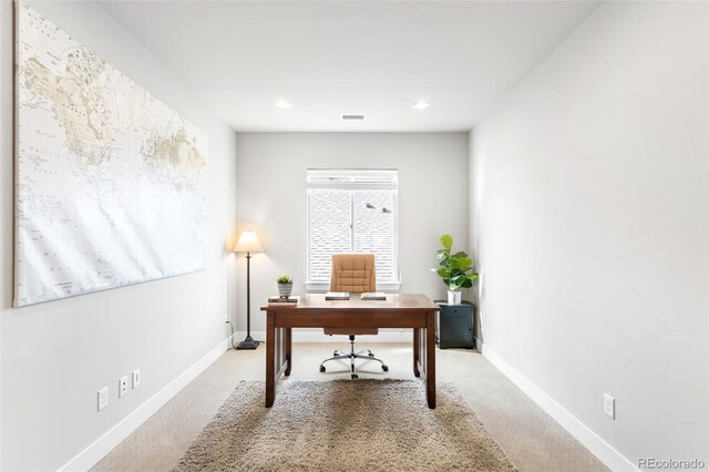 home office with light carpet, visible vents, and baseboards