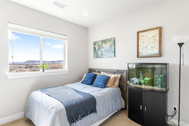 bedroom with baseboards, a mountain view, visible vents, and light colored carpet