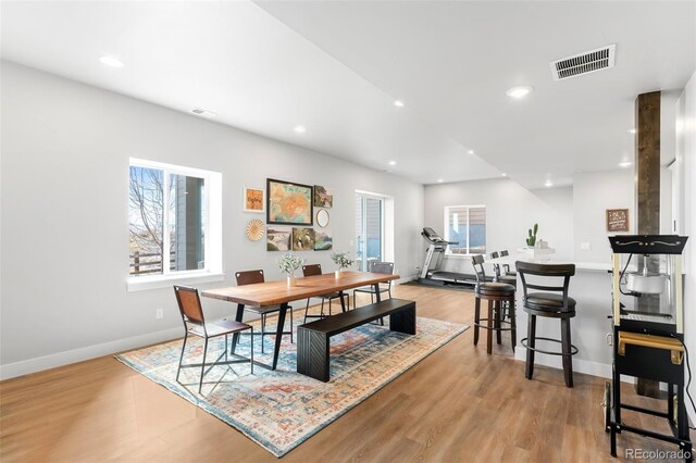 dining room featuring light wood finished floors, baseboards, visible vents, and recessed lighting