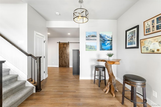 interior space with stairs, light wood-style flooring, baseboards, and a barn door