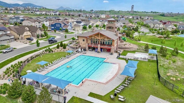 pool with a residential view, fence, a mountain view, and a patio