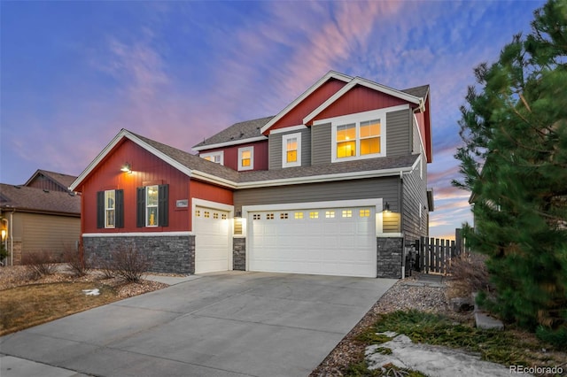 craftsman house featuring a garage, stone siding, fence, and concrete driveway