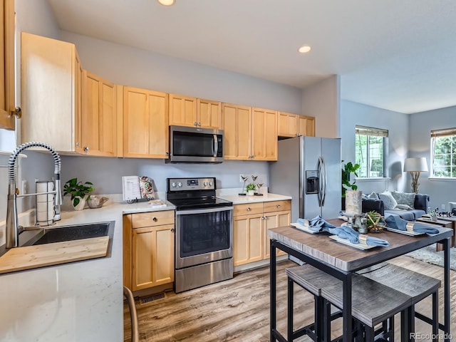 6065 Wadsworth Blvd Unit A, Arvada, CO 80003 - kitchen featuring stainless steel appliances, light brown cabinetry, light countertops, a sink, and light wood-type flooring