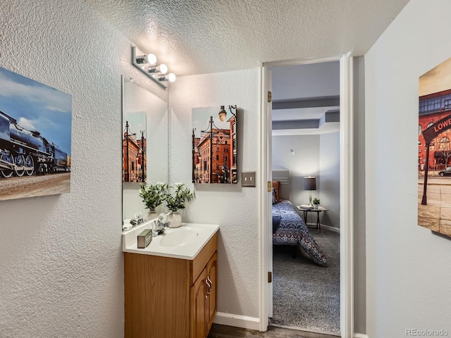 6065 Wadsworth Blvd Unit A, Arvada, CO 80003 - ensuite bathroom featuring a textured wall, vanity, and a textured ceiling