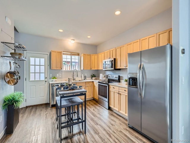 6065 Wadsworth Blvd Unit A, Arvada, CO 80003 - kitchen featuring stainless steel appliances, light brown cabinetry, light countertops, light wood finished floors, and recessed lighting
