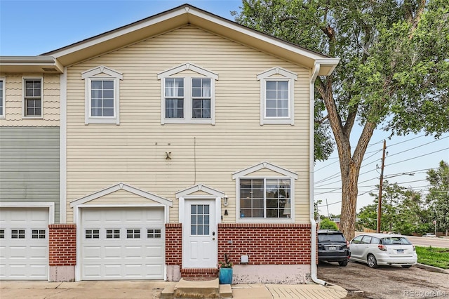6065 Wadsworth Blvd Unit A, Arvada, CO 80003 - view of property with brick siding, a garage, and driveway