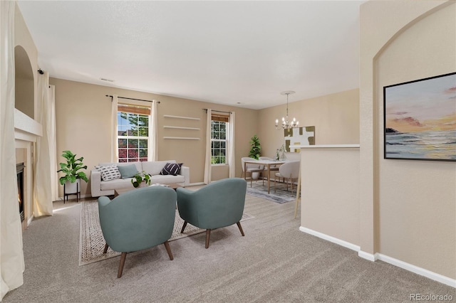 12784 Jasmine St Unit E, Thornton, CO 80602 - living area with carpet floors, a chandelier, and a fireplace with flush hearth